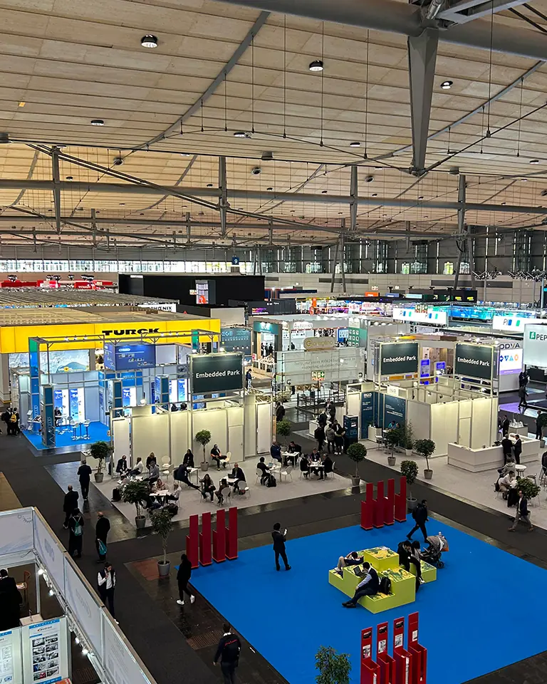 Blick über eine Fachmesse mit zahlreichen Ausstellern und technischen Produktlösungen